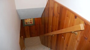 A wooden staircase with a handrail, carpeted steps, and a small framed picture on the wall. - Felker's Cottage: Fall Color Getaway | Lakefront Cottage Near Tunnel of Trees (Vanderbilt)