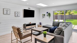 Una sala moderna con un sofá, una mesita de centro y una televisión.