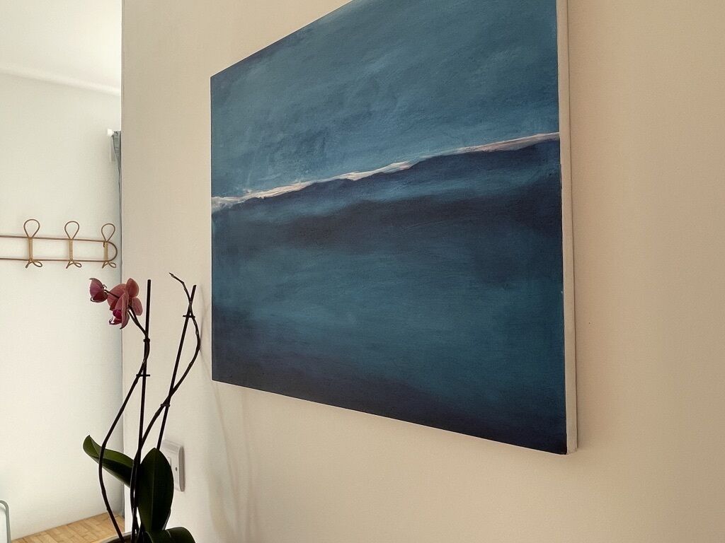 A painting of a blue ocean on a wall.