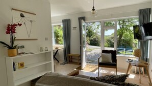 Una camera moderna con un letto, una scrivania e vista sull'esterno.