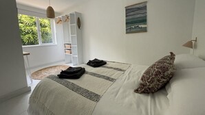 Une chambre à coucher avec un lit, une fenêtre, une étagère et un tableau.