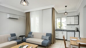 Un salon moderne comprenant un canapé, une table basse et un coin repas avec une table et des chaises.