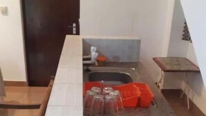 A kitchen with a tiled backsplash, a sink, and a countertop. - Stay.Plus 2 Bedroom Shree Apartment (Mombasa)