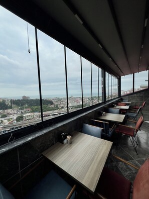A restaurant with a view of a cityscape through large windows. - White House Apart (Trabzon)