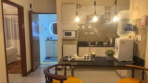 Une cuisine moderne dotée d’un îlot central, d’un éclairage suspendu et d’un réfrigérateur.