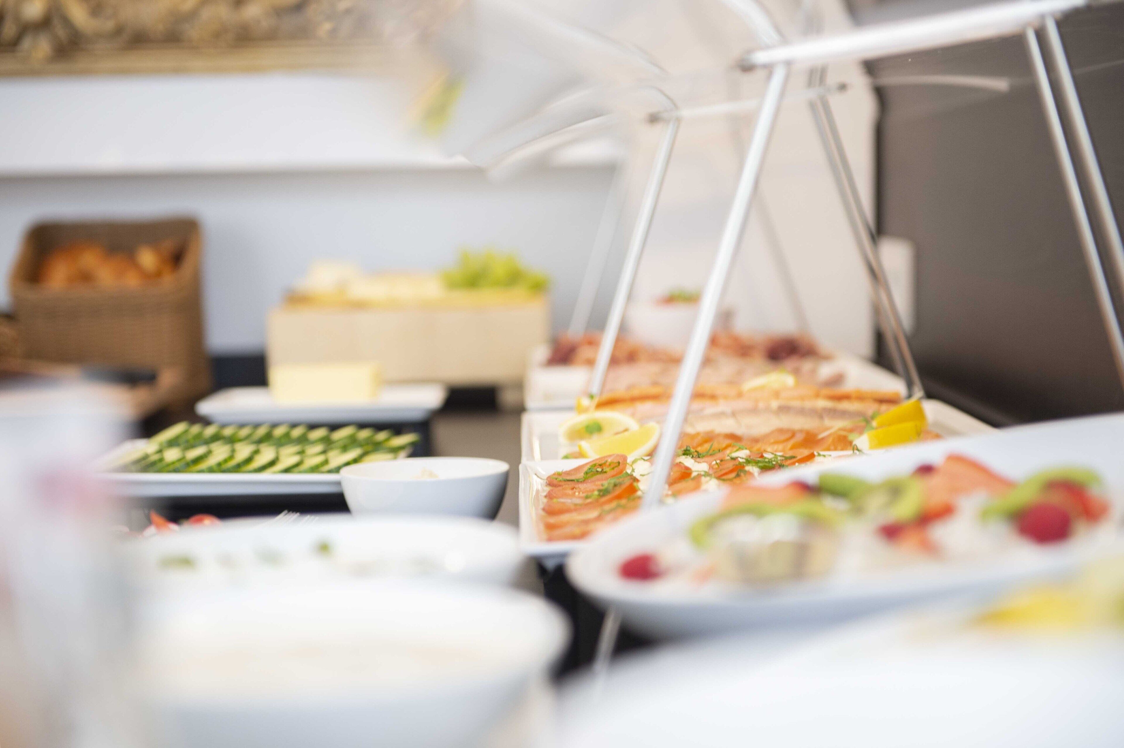 A buffet with various dishes and a basket of bread.