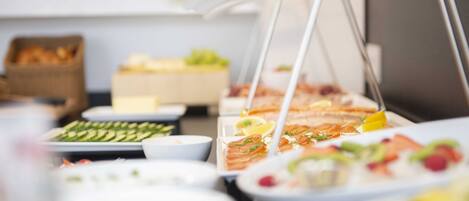 A buffet with various dishes and a basket of bread.