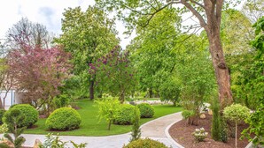 Un jardin aménagé avec des allées sinueuses, différents arbustes et arbres.