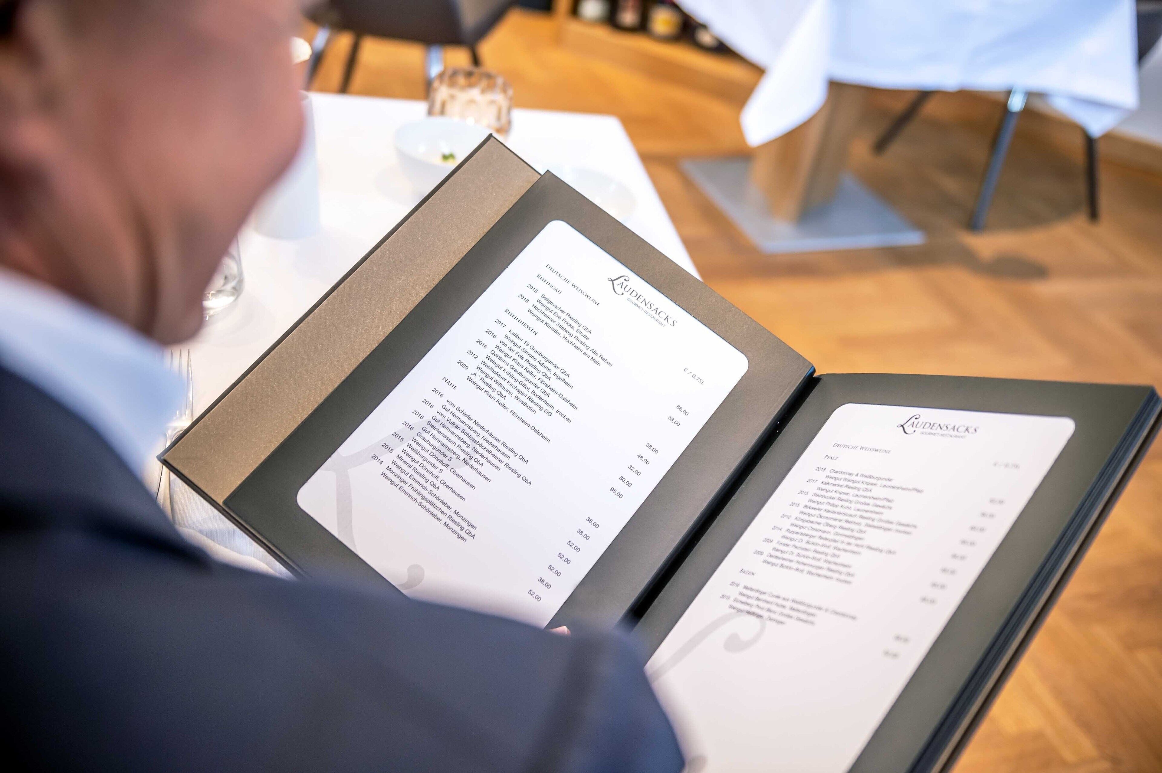 A person reading a menu at a restaurant.