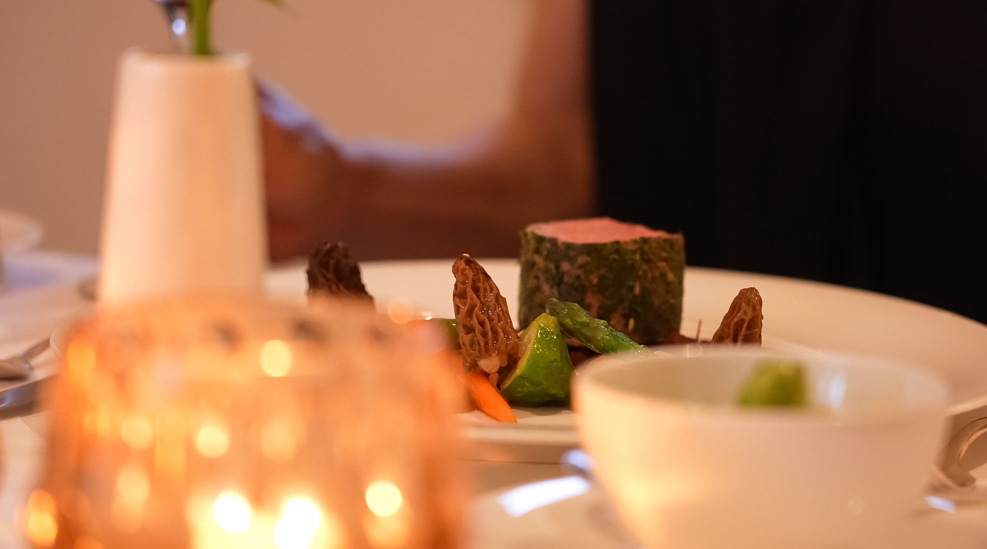 Ein Nahblick auf einen Dessertteller mit verschiedenen Speisen, darunter ein Stück Fleisch und Gemüse.