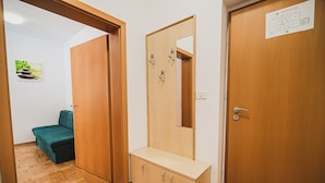 Ein Zimmer mit einem Bett, einem Holzschrank, einem Spiegel und einer Tür.