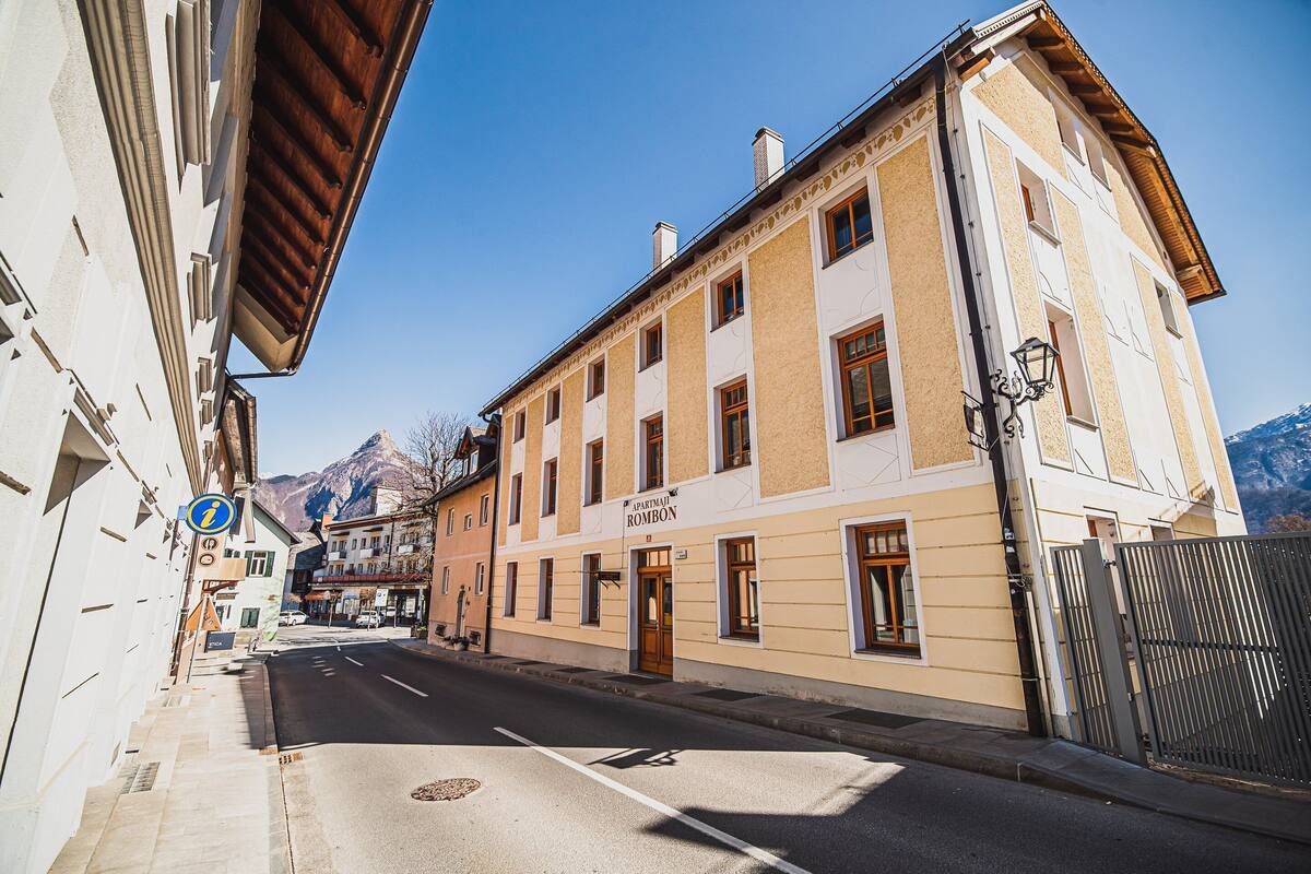 A street view with a building labeled "Hotel Rombon" and a mountain in the background.