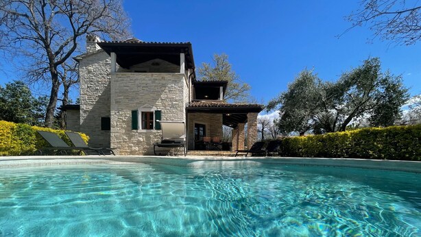 A stone building with a pool in front.