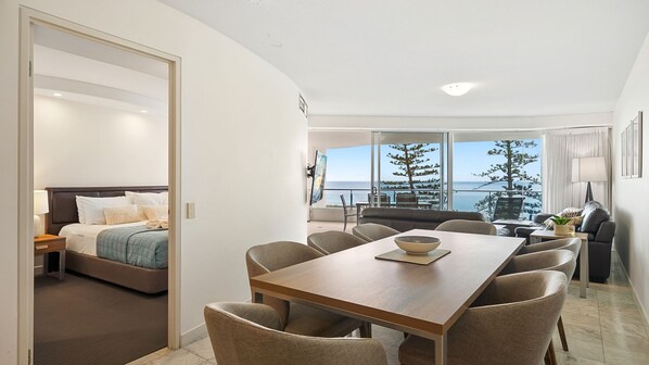 Et moderne hotelværelse med balkon, spiseplads og seng med udsigt.