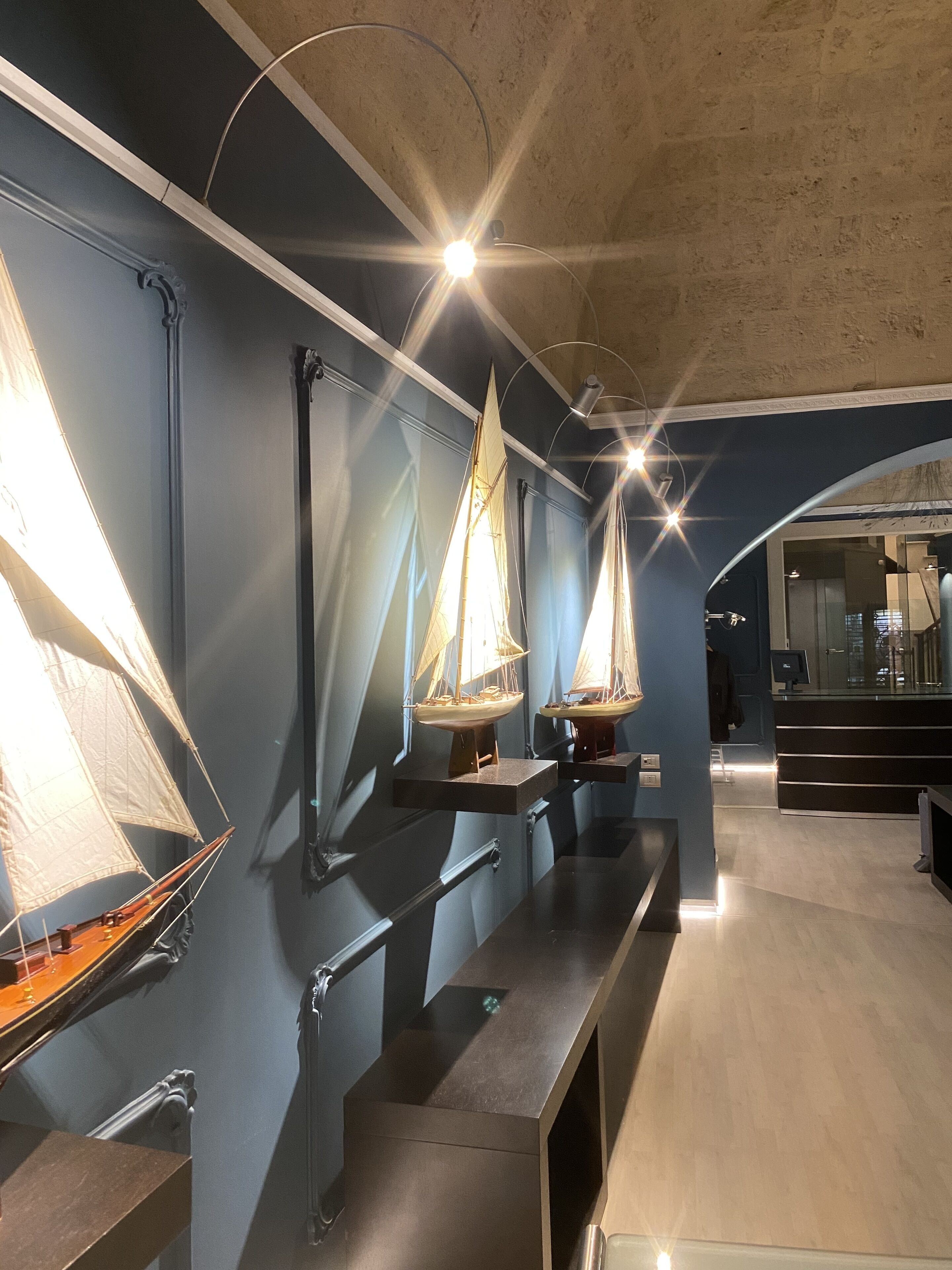 Un intérieur moderne avec un long comptoir où sont exposés des modèles de voiliers.