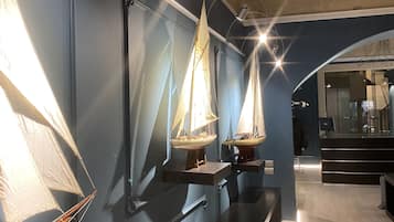 A modern interior with a long counter displaying model sailboats.