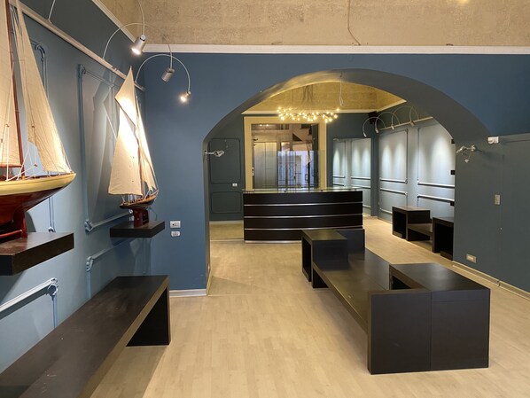 Um interior moderno com piso de madeira, um modelo de veleiro e um banco.