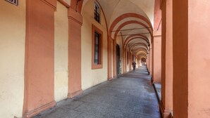 Ein Korridor mit gewölbter Decke und Fliesenboden, der in die Ferne führt.