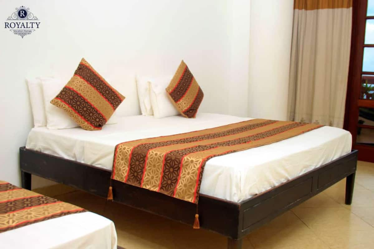 A hotel room with a bed, pillows, and a blanket.