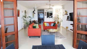 An open-plan living area with two sofas, a coffee table, and a dining table. - Stay.Plus Shanzu Beachfront Apartment (Mombasa)