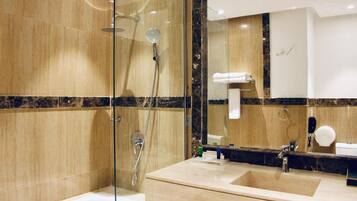 Een bad/douchecombinatie, een haardroger, badjassen, een bidet