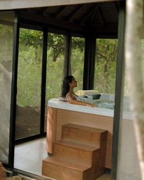 A woman relaxing in a hot tub with a view of greenery outside. - The Postcard Hideaway Netravali Goa (Sanguem)