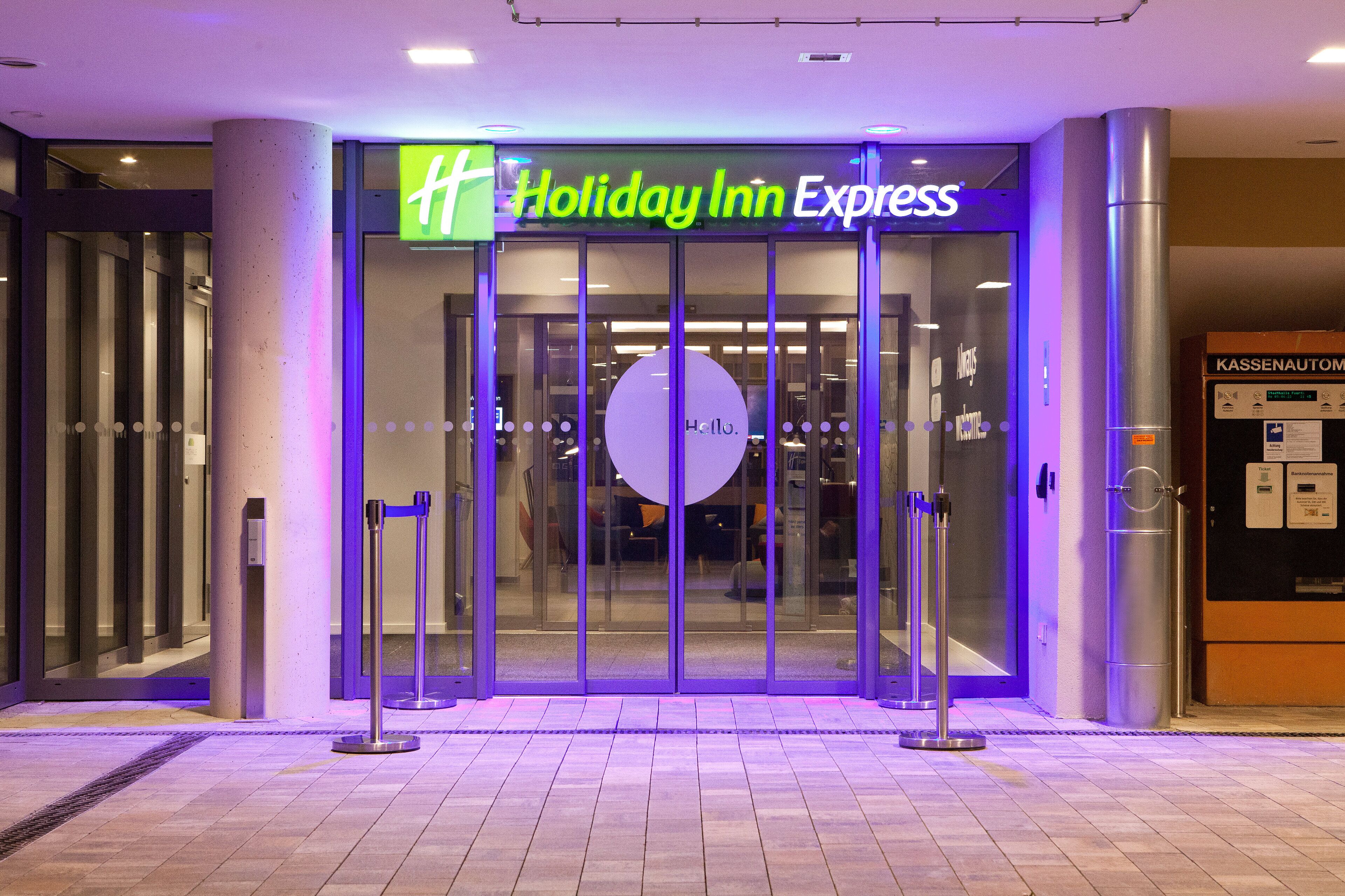 Der Eingang eines Holiday Inn Express mit Glastür und Drehkreuz.