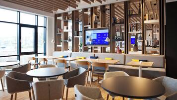 Une bibliothèque moderne, dotée d’étagères, de tables et de chaises.