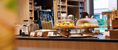 A bakery counter with various baked goods and kitchen equipment.