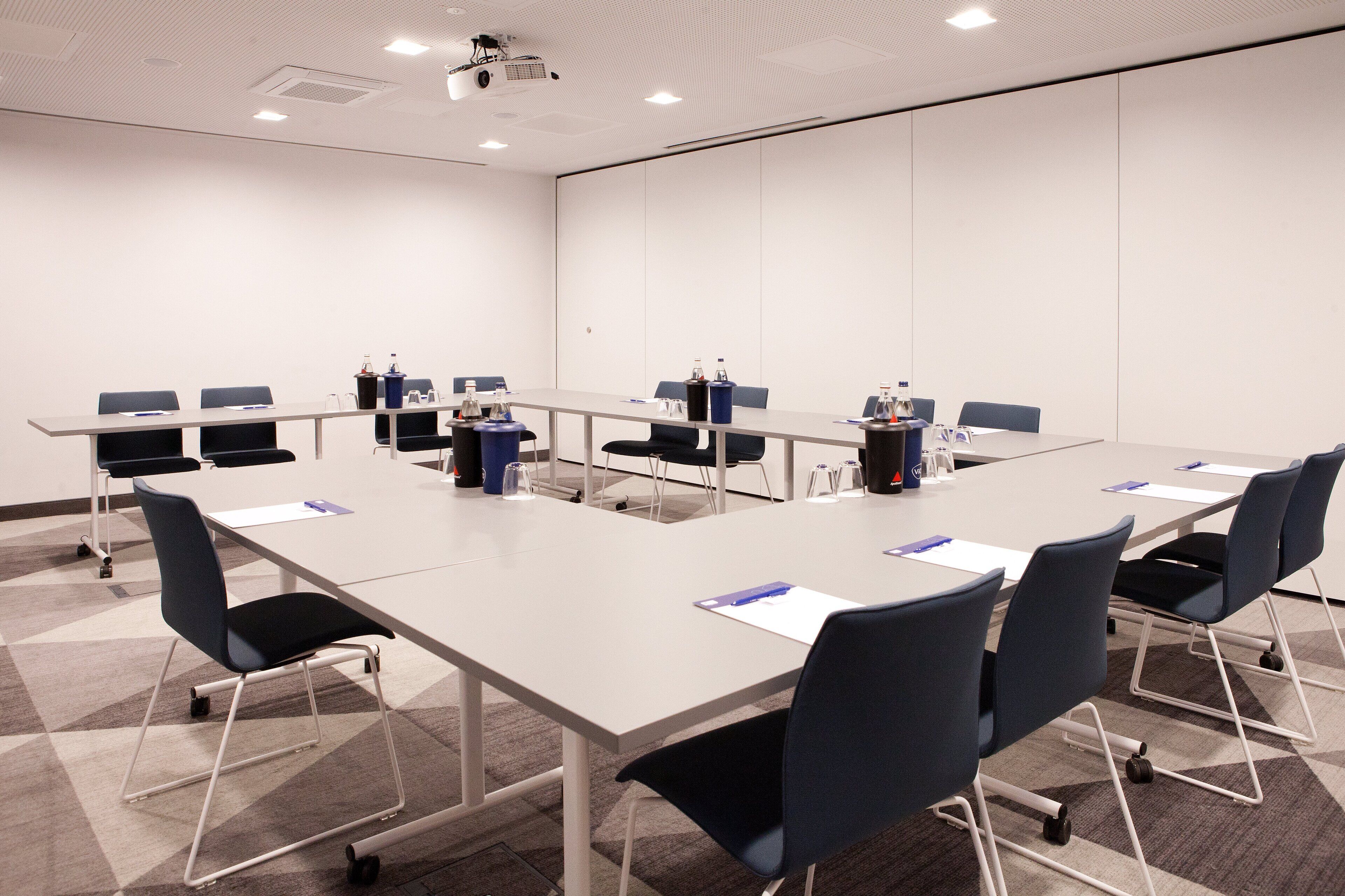 A conference room with a long table, chairs, and water bottles.