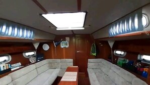 Un interior compacto con dos zonas de asientos acolchados, una mesa central e iluminación en el techo.