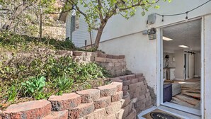 A brick staircase leading to a door with a 'WELCOME' mat, a tree, and string lights. - On-Site Trails! Hot Tub Hideaway in Zion Area (Hurricane)