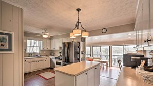 A spacious kitchen with a large island, modern appliances, and a view to the outdoors. - Lakefront Lavonia Cottage w/ 2-Story Dock! (Lavonia)