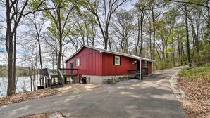 A red cabin with a dock, surrounded by trees and a lake. - Lakefront Lavonia Cottage w/ 2-Story Dock! (Lavonia)