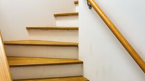 En trætrap med gelænder, der fører op til en etage.