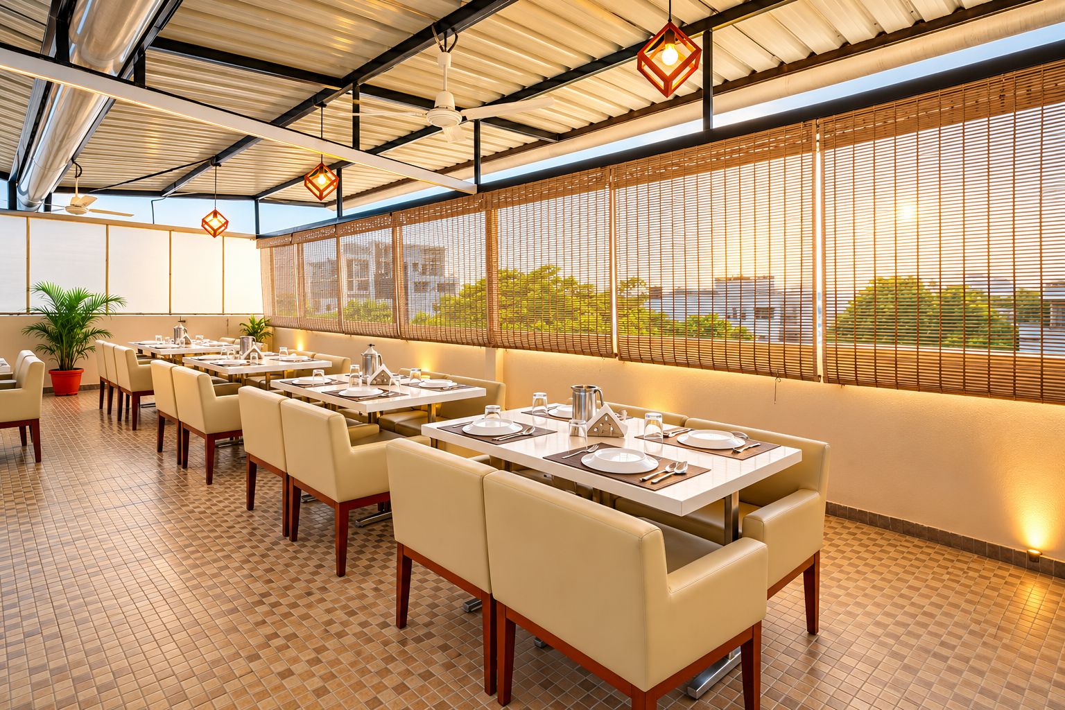 Un restaurant amb taules preparades per dinar, un ventilador al sostre i una vista per una finestra amb persianes.