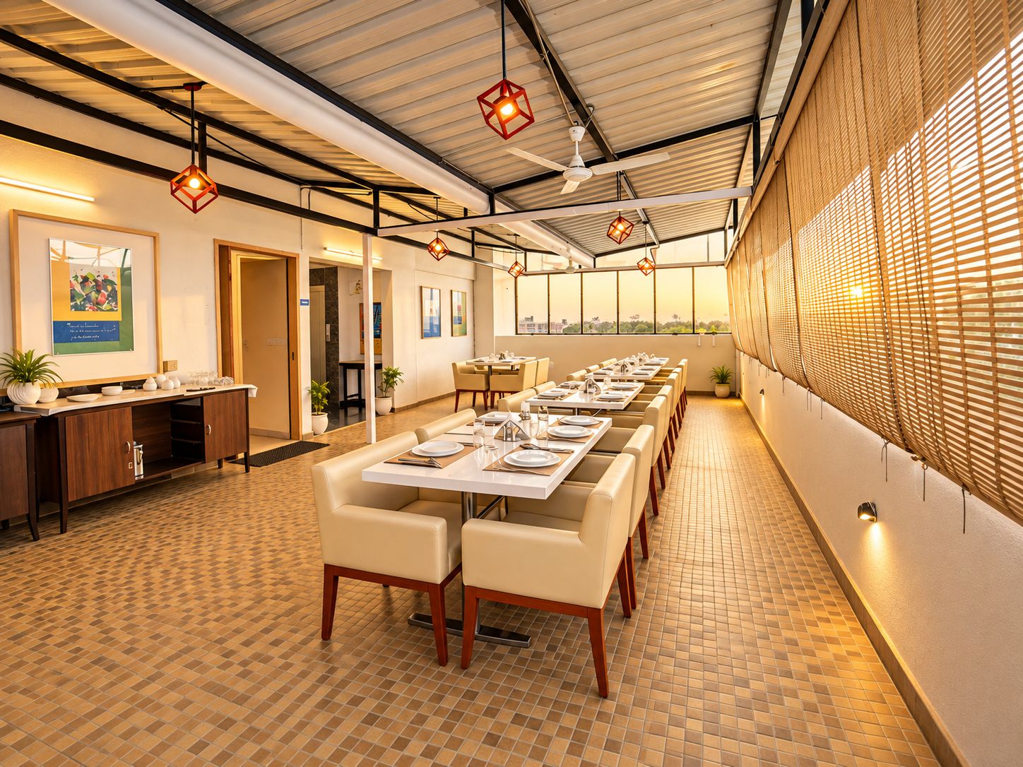 A restaurant with a long dining table, chairs, and hanging lights.