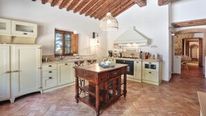 Une cuisine spacieuse avec des meubles en bois, un îlot central et un luminaire suspendu.