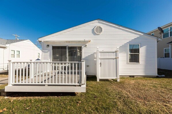A single-story house with a front porch, a small attached garage, and a clear sky. - Newly Redecorated Beach Home in Wildwood Crest (Wildwood Crest)