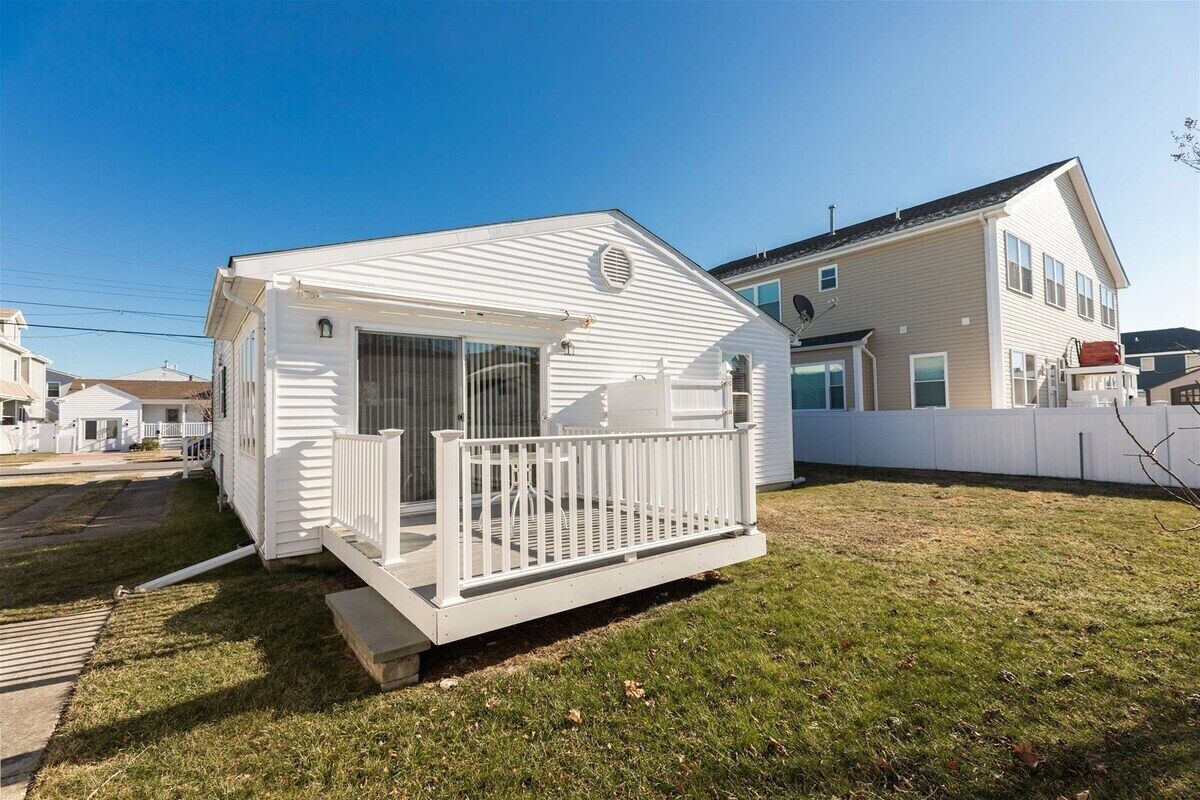 A single-story house with a front porch and a small deck.