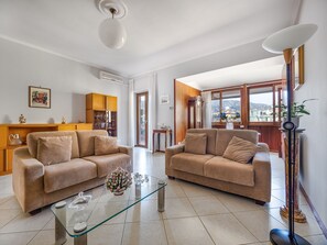 A living room with two beige sofas, a glass coffee table, and a wooden cabinet. - Mayor House (Sorrento)