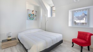 A modern bedroom with a bed, a red chair, a floor lamp, and a painting on the wall. - Large house for 8 people in St Armel (Saint-Armel)