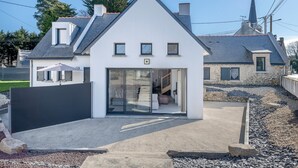 A modern house with a white facade, a sloped roof, and a stone exterior. - Large house for 8 people in St Armel (Saint-Armel)