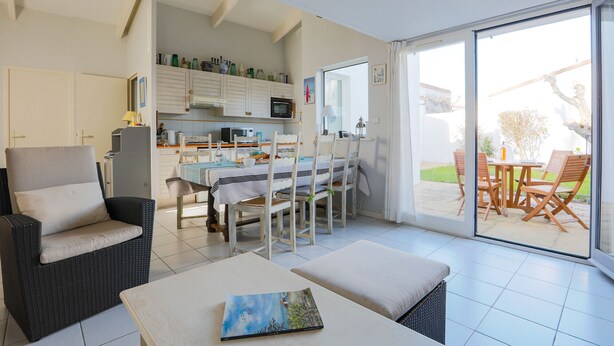A modern kitchen with white cabinets and a dining area with a table and chairs. - Cosy family house for 6 in Les Portes en Ré (Les Portes-en-Ré)