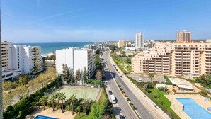 Un quartier résidentiel avec de grands immeubles, une route et une plage en arrière-plan.