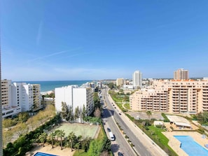 Un quartier résidentiel avec de grands immeubles, une route et une plage en arrière-plan.