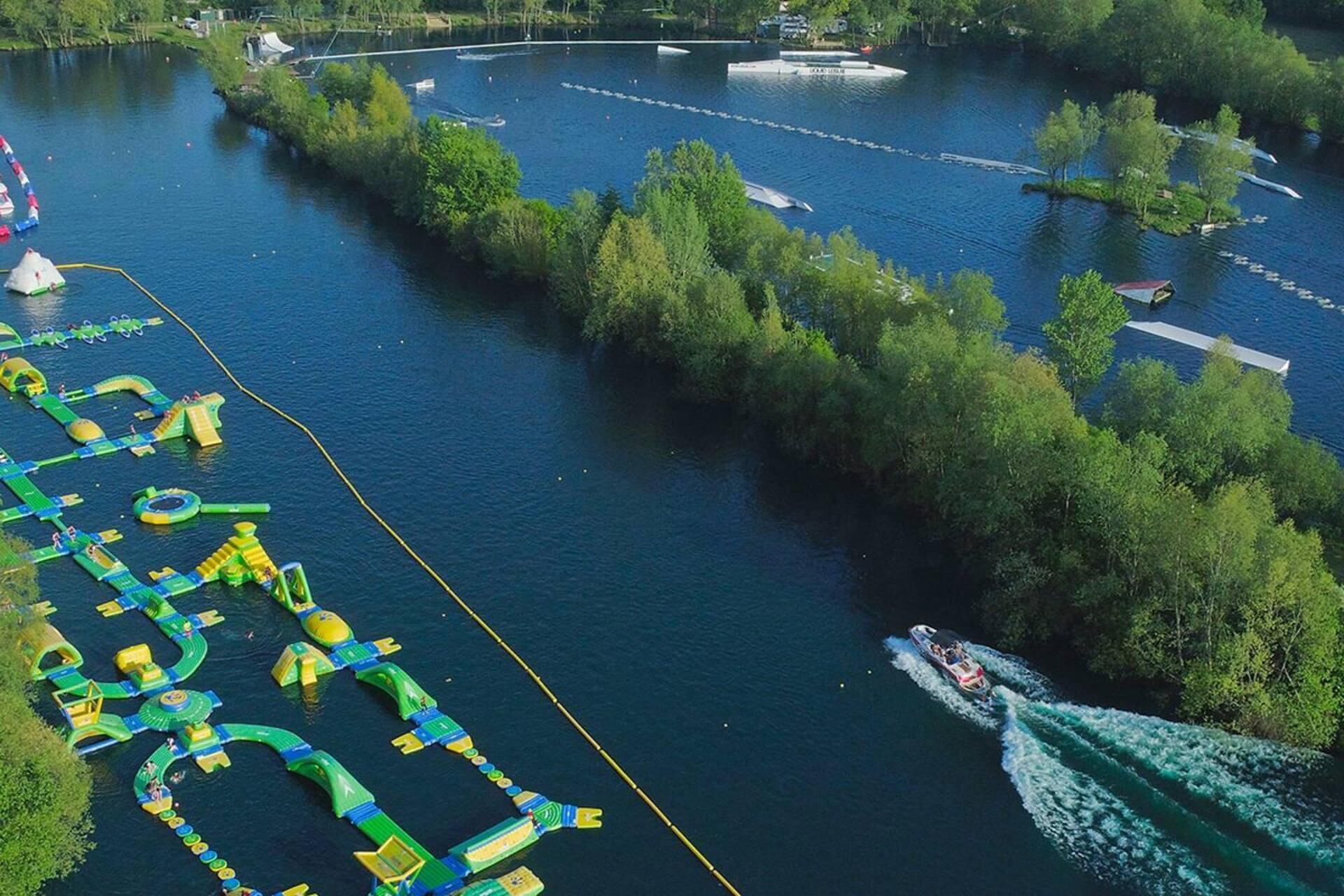 Vue aérienne d’un parc aquatique avec différents toboggans et une attraction proposant une promenade en bateau.