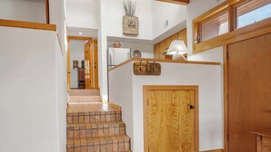 A staircase with a wooden door at the bottom, a small shelf with a lamp, and a window above. - Amazing Mountain Views, Communal Pool (Santa Fe)