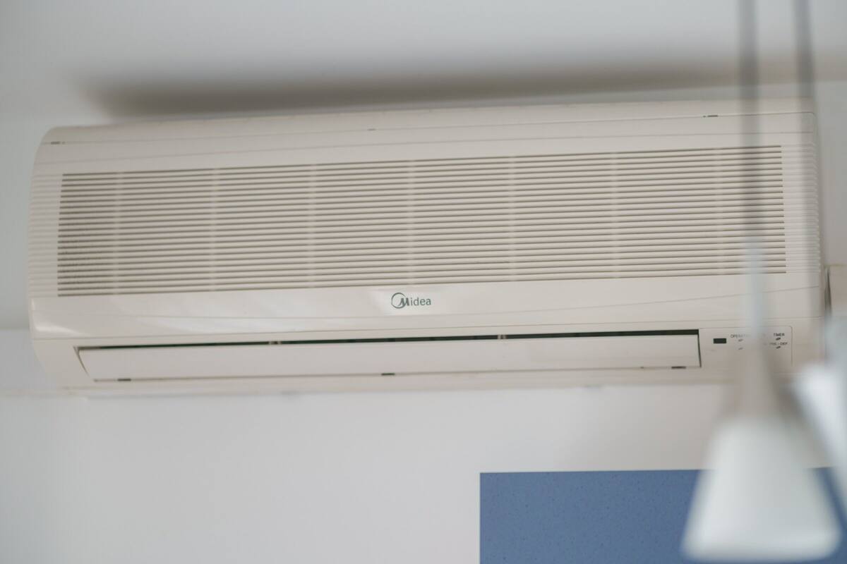 Un climatiseur blanc de la marque Midea, fixé au mur.