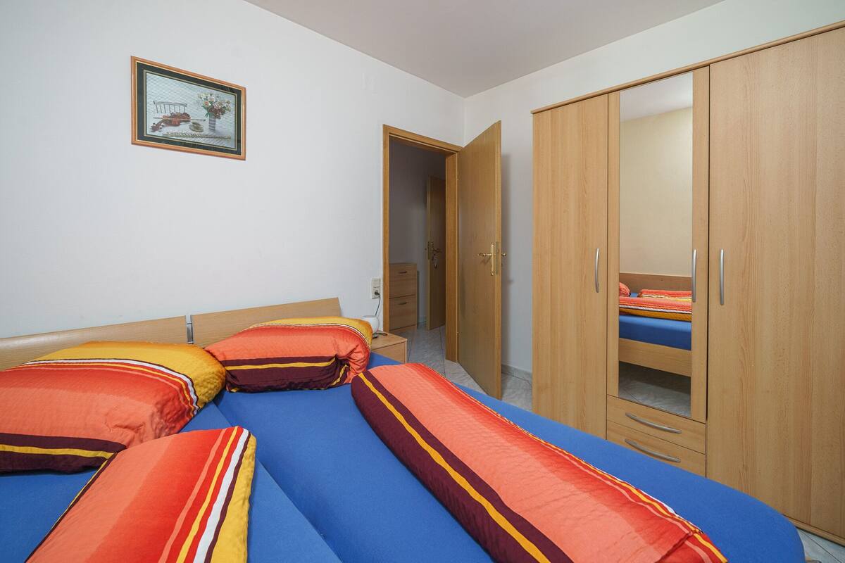 Une chambre à coucher avec un lit, une armoire et une petite table de chevet.